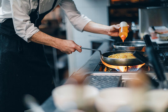 Chef preparing a dish in traditional Italian restaurant kitchen