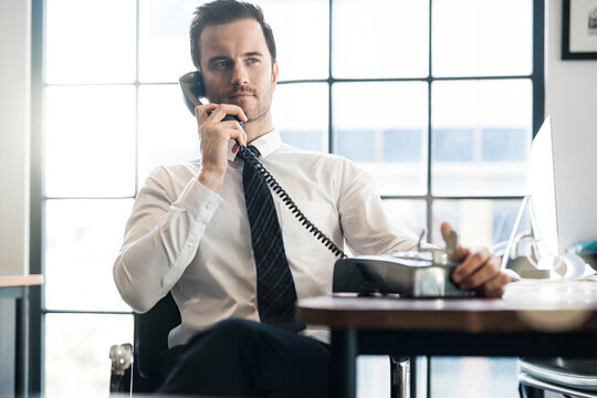 Businessman in office using vintage retro telephone