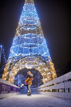 Happy young couple hugging on an illuminated festive ce rink at night