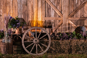 Rustic barn interior with wooden wagon wheel, hay bales and farm decor, vintage countryside still life with wooden wall background, rural tradition and agriculture concept.
