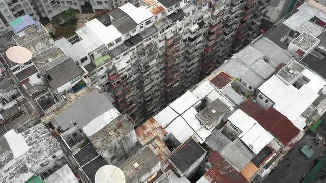 Tilting drone shot of illegal small houses built on top of government subsidized apartment complex in Hong Kong