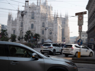 Fototapeta premium Rush hour traffic in Milan with cars and taxis. Blurred motion photo