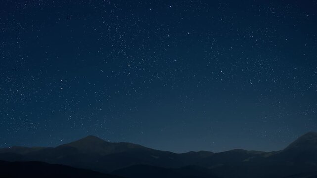 movement of stars in the night sky with the view of mountains.