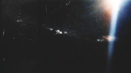 Retro distressed film effect with scratches, dust particles and light leaks. Noisy grain texture with light leak flares on black background. © li