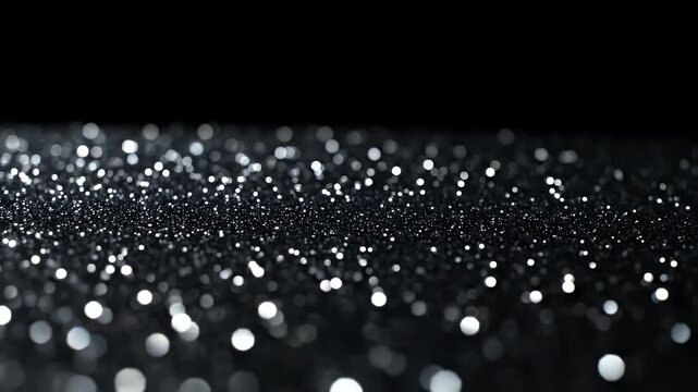 Silver glitter sparkling on dark background with bokeh lights