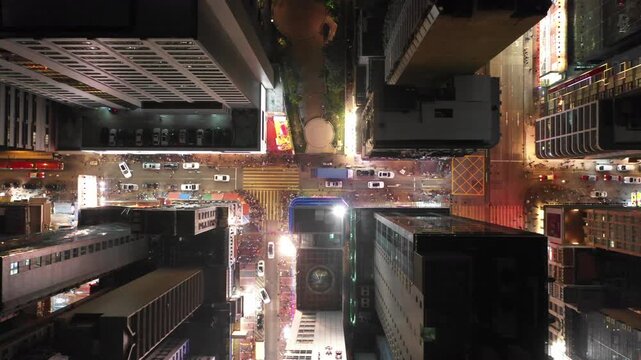 Asia infrastructure and transportation - overhead panning drone shot of traffic and pedestrians in illuminated streets of Hong Kong