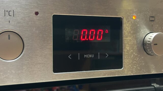 The digital oven interface displays a red timer while the internal cooling fan circulates air. This kitchen operation produces a steady, low-frequency hum followed by short, sharp electronic beeps.