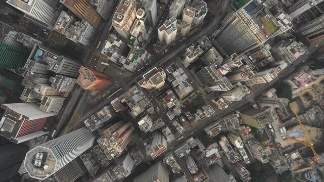 Overhead drone flight of dense high-rise apartment buildings and commercial office towers on Hong Kong island