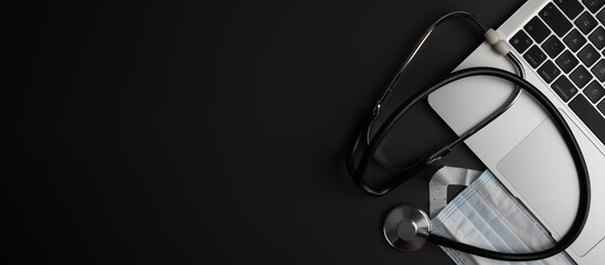 ICU - Intensive Care Unit - concept on doctor's desk. Wooden cubes, stethoscope, mask and laptop keyboard representing modern medical workflow