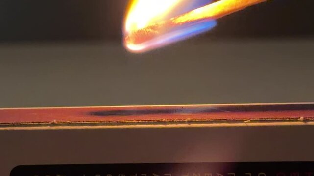 A wooden match strikes against a rough friction strip. This action creates a sharp scraping sound followed by a sudden hiss as the head ignites. A soft crackling noise continues as the flame burns.