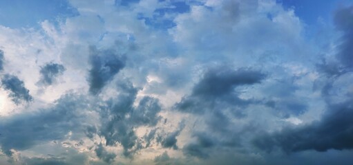 Dramatic wide angle panorama of moody blue storm clouds at sunset