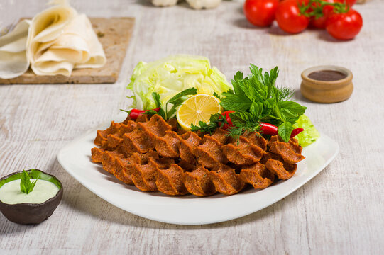 Turkish Cig kofte Plate with Fresh Herbs Lemon and Sauce