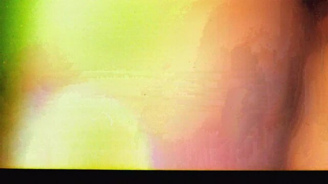 Vintage film roll light leak transition overlay. Authentic retro 8mm or 16mm damaged celluloid strip with sprocket holes, dust, and scratches. Abstract glowing colorful cinematic grunge background