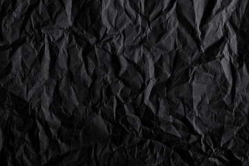 Black crumpled paper texture background. Dark black crumpled paper texture with deep folds and shadows. Minimal abstract luxury background
