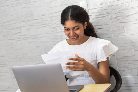 Young woman receiving university acceptance letter with excitement