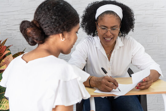 Mother helping student writing university acceptance letter