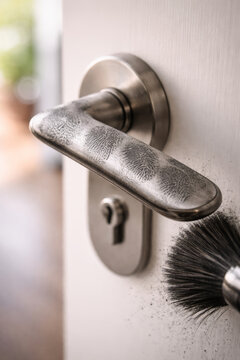 Close-up of a door handle with fingerprint dusting detail