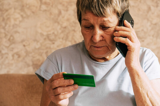 A naive elderly woman gives her bank card details to telephone scammers. Financial fraud using personal information, manipulation, criminal activity