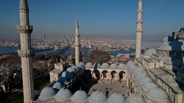 Aerial view of Suleymaniye Mosque featuring its domes, minarets and courtyard, combined with the Golden Horn, Istanbul cityscape and historic peninsula. Ottoman architecture meets city skyline.