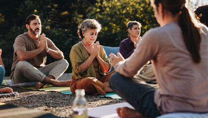 People practicing outdoor meditation or prayer in a natural setting.