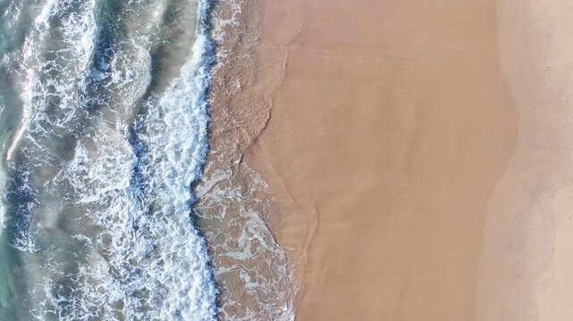Beautiful sea summer landscape, Waves sea water surface High quality video Bird's eye view, Drone top view waves crashing on sand beach,Nature ocean sea beach background