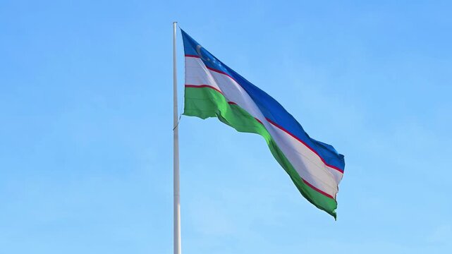 Uzbekistan Flag Waving in Blue Sky &ndash; National Symbol of Uzbekistan