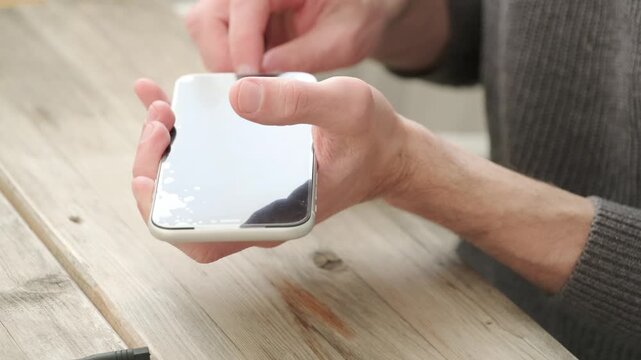Mobile phone repair scene with new screen replacement kit and opened smartphone on wooden desk. Tech service concept