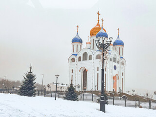 Fototapeta premium Orthodox church with blue and gold onion domes in snowy winter weather, Sakhalin