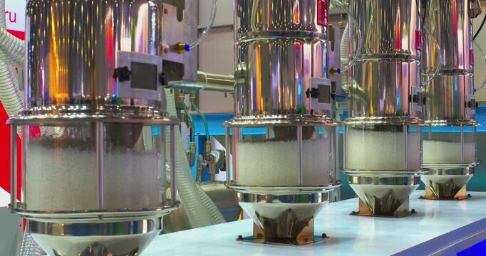 Advanced pneumatic conveyor system automatically transports plastic polymer granules for processing in a factory, demonstrating modern industrial manufacturing technology and automation concepts