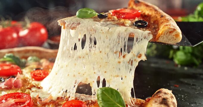 Super slow motion footage (1000 fps) of a pizza slice being lifted with perfectly melted, stretchy cheese. Rich textures of crust, prosciutto, tomato and fresh basil in cinematic light.