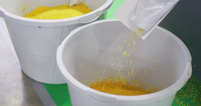 Industrial equipment efficiently transfers plastic pellets into a storage bin, highlighting the advanced methods used in large-scale plastic processing operations.