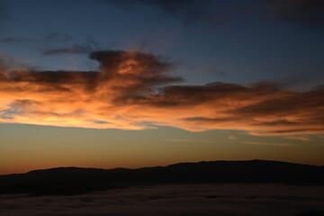 Fototapeta premium stunning view of a sunrise between fog ans sky