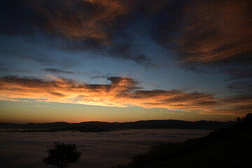 Obraz premium stunning view of a sunrise between fog ans sky
