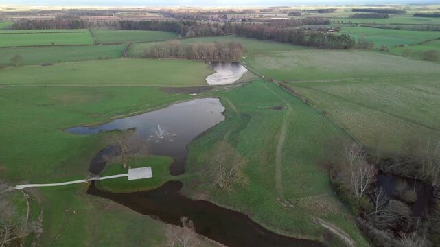 A drone captures a view of green fields and ponds in Northumberland 