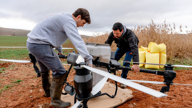 Farmers positioning agricultural drone in field