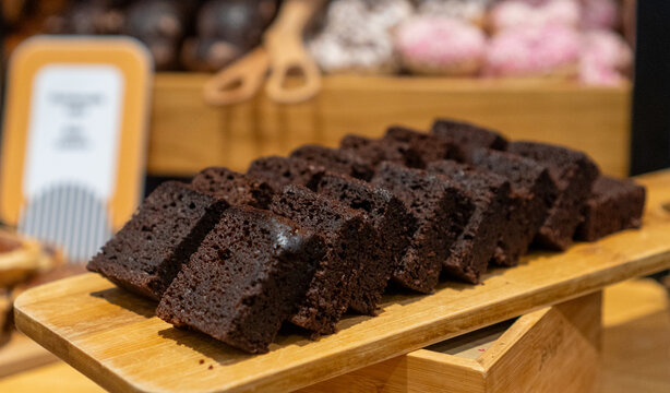 Sliced dark chocolate sponge cake on board.
