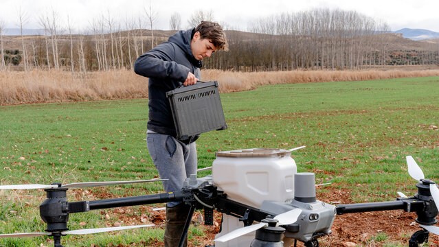 Farmer installing battery on agricultural drone