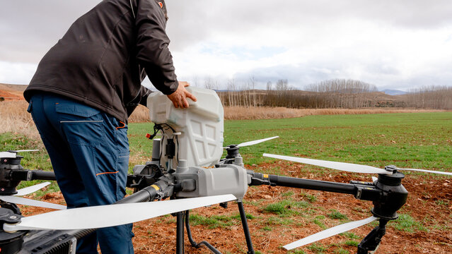Farmer checking main tank of agricultural drone