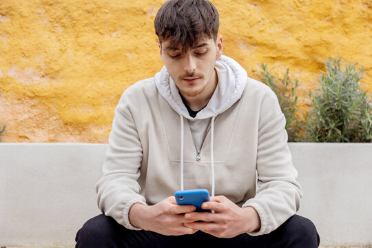 Young man using a smartphone in an urban setting