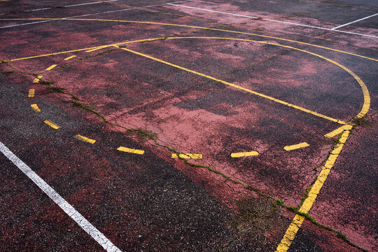 Weathered outdoor basketball court with cracked lines