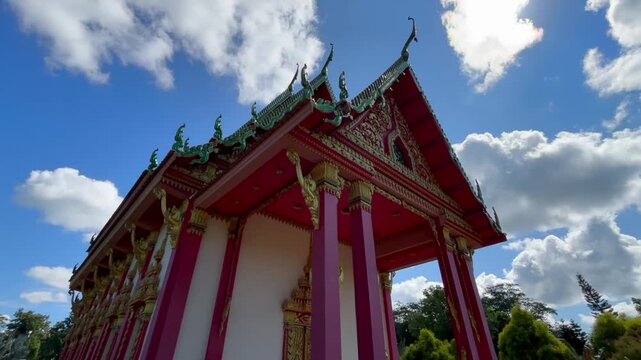 Namsai, Arunachal Pradesh, India &ndash; 17 February 2026: A low-angle view of an ornately decorated Buddhist temple featuring red pillars, golden carvings, and traditional roof details.