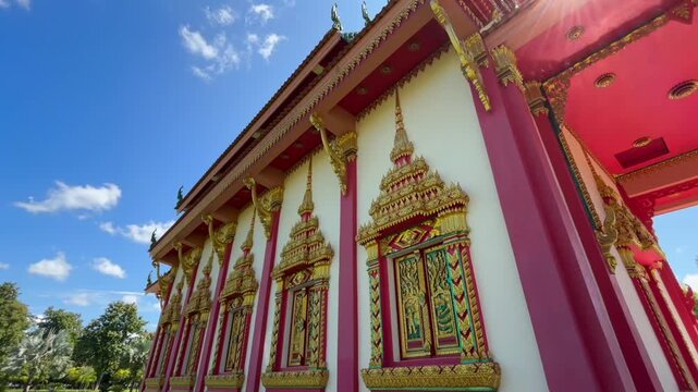Namsai, Arunachal Pradesh, India &ndash; 17 February 2026: A detailed side view of a Buddhist temple featuring ornate golden window frames, red pillars, and intricate traditional carvings.