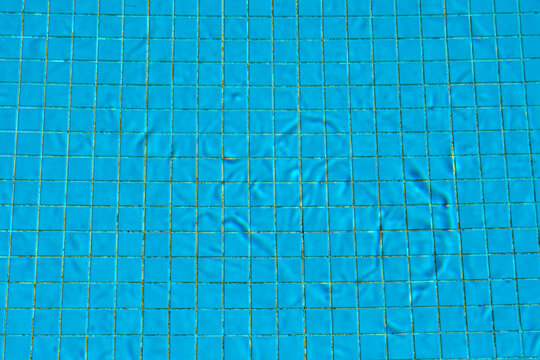 Blue tiled pool surface with water ripples