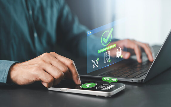 successful online shopping, approved payment, ecommerce checkout completion, Man hands using smartphone and laptop with order confirmed and payment approved hologram for secure e-commerce transaction