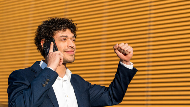 Young professional celebrates success on phone call