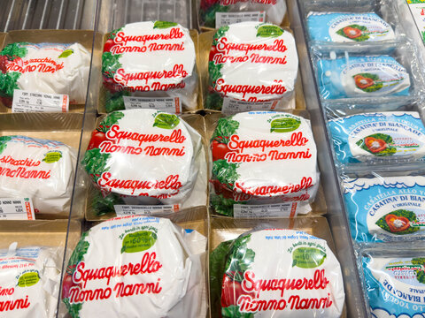 Venice, Italy - February 14, 2026: Squacquerone cheese packages displayed on a shelf in a grocery store, featuring vibrant labels and various types of cheese visible