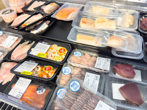 Venice, Italy - February 14, 2026: Assorted seafood packages displayed in a supermarket refrigerator, including salmon, tuna, and various fish fillets in clear plastic containers