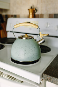 Teapot on stove with wooden handle and speckled design