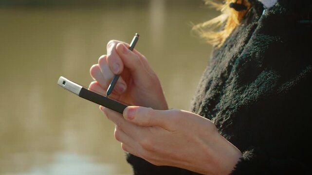 Stylus organizing digital to do list on smartphone during daily planning routine. Tasks prioritizing and schedule arranging through mobile productivity application. Workflow optimizing and reminders