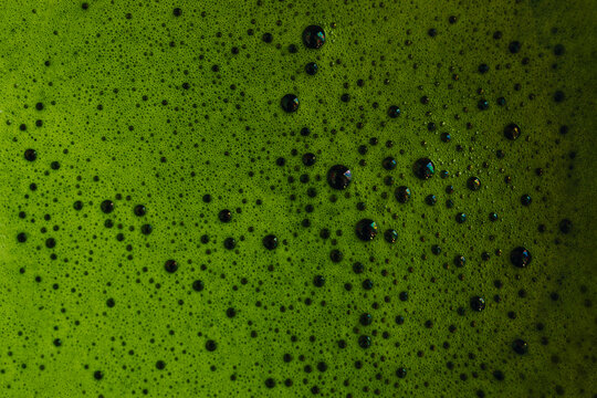 Close-up of vibrant matcha tea with frothy bubbles